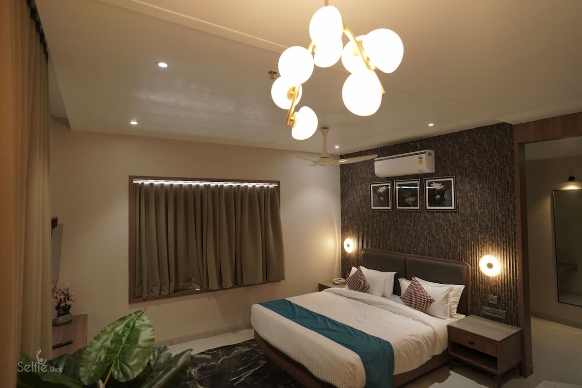 Une chambre moderne avec un grand lit, des tables de chevet, un ventilateur de plafond et un appareil de climatisation.