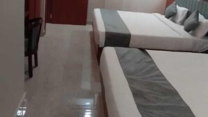 A hotel room with two beds, a ceiling fan, and an air conditioning unit. - Hotel Vijay Villas (Udaipur)