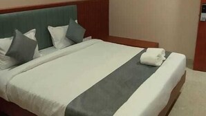 A hotel room with a large bed, a wooden headboard, and a ceiling fan. - Hotel Vijay Villas (Udaipur)