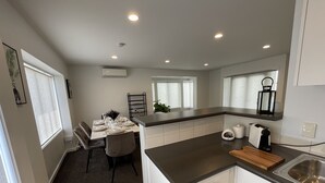 Una cocina moderna con armarios blancos, encimera oscura y un lavamanos empotrado.