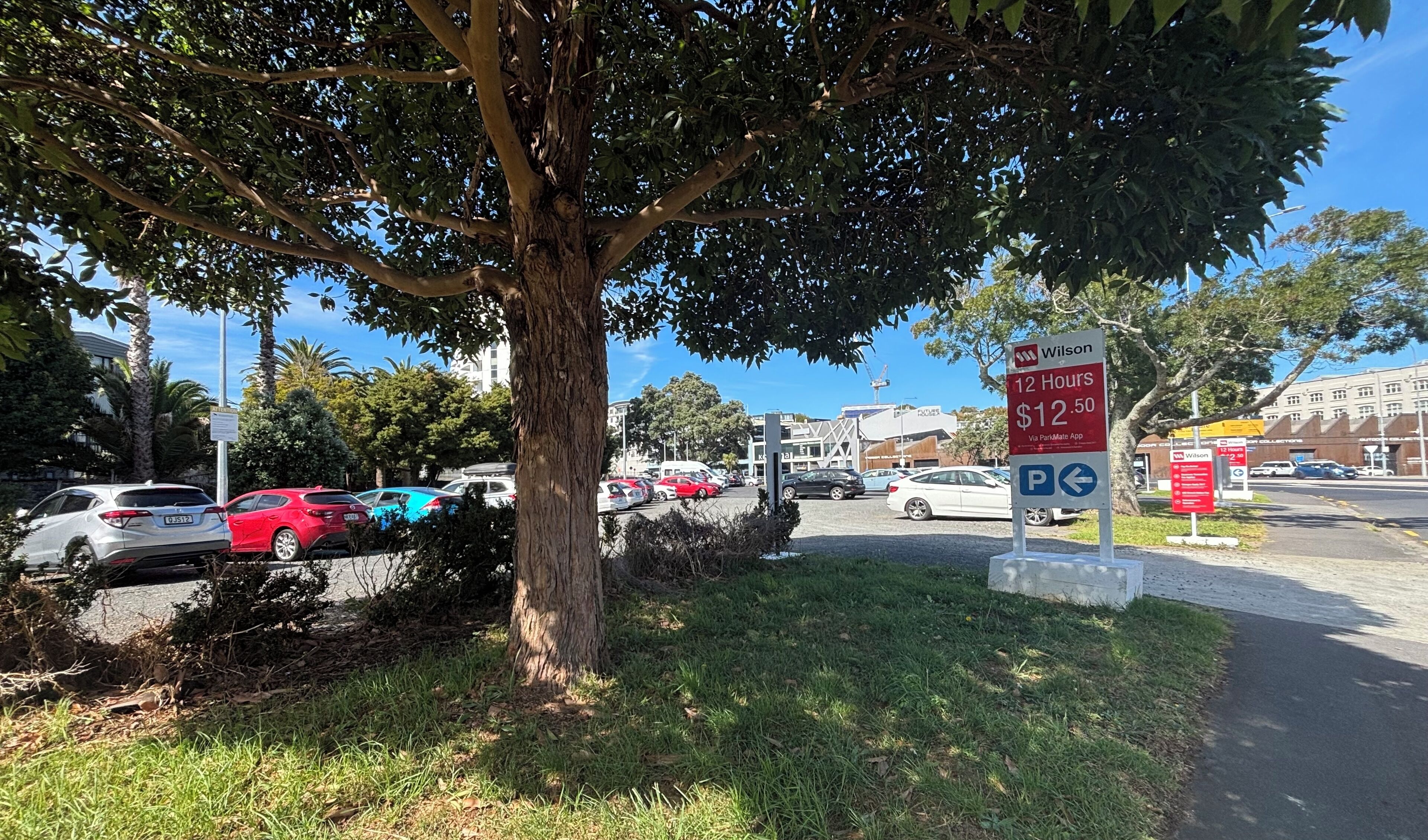 A parking area with a sign indicating a 12-hour parking rate of $12.50 via ParkMate app.
