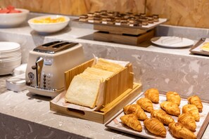 Enjoy a delicious breakfast spread with a variety of options, including fresh fruit, pastries, and warm bread.
