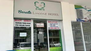 Entrada de hotel con carteles que muestran la disponibilidad de habitaciones e información de contacto.