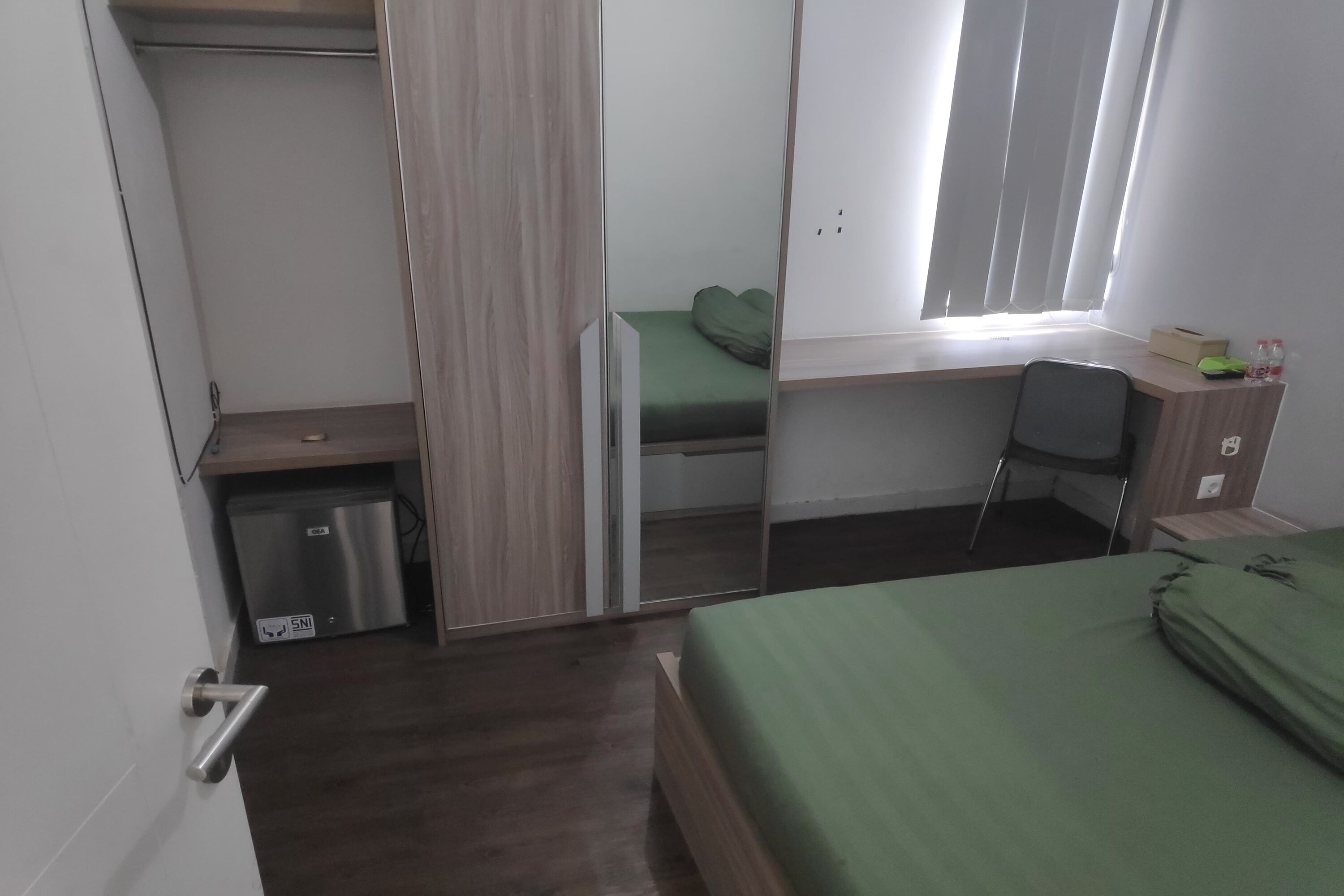 Una habitación pequeña con cama, escritorio y silla.