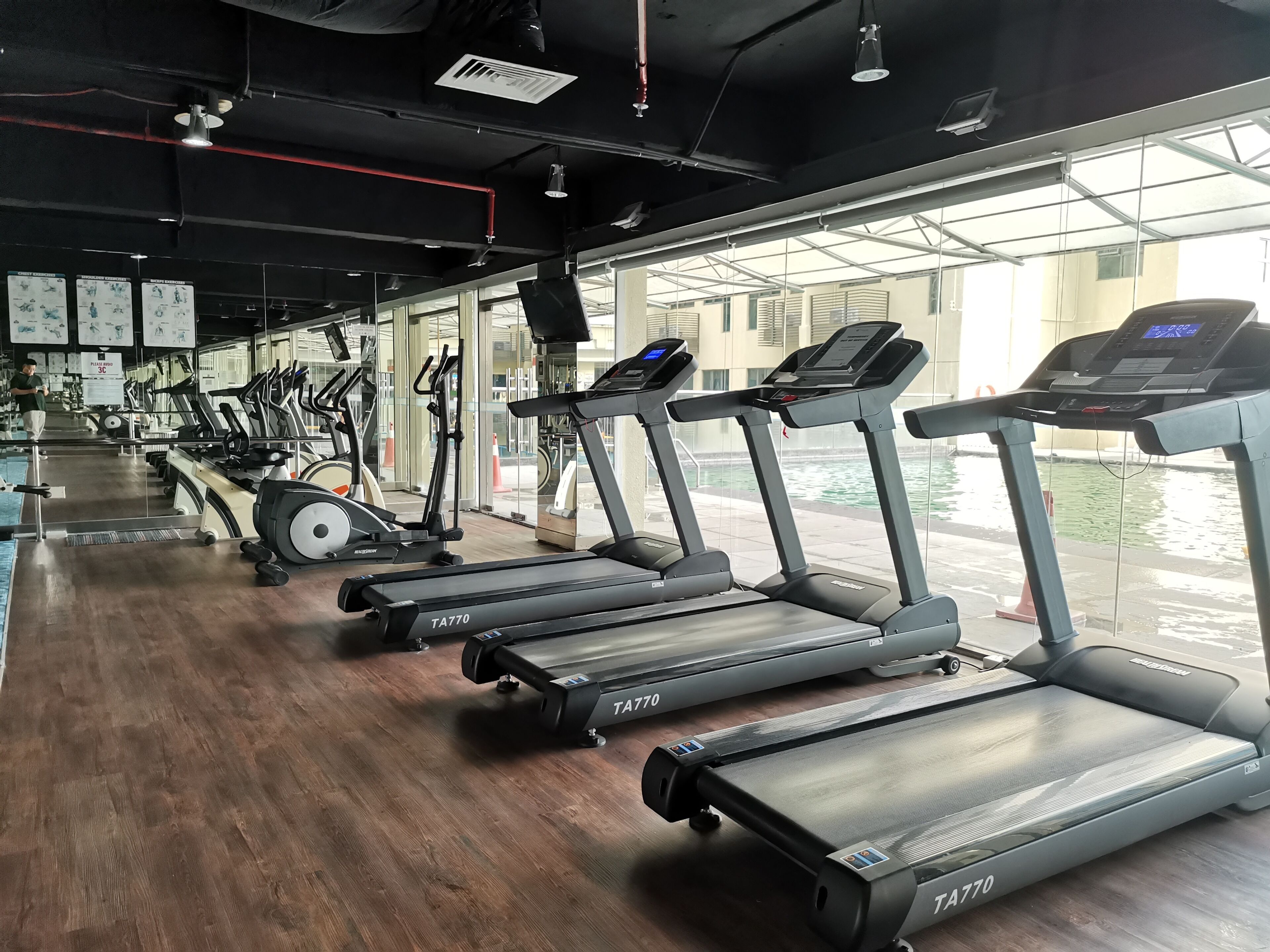 A gym with multiple treadmills, exercise bikes, and weights.