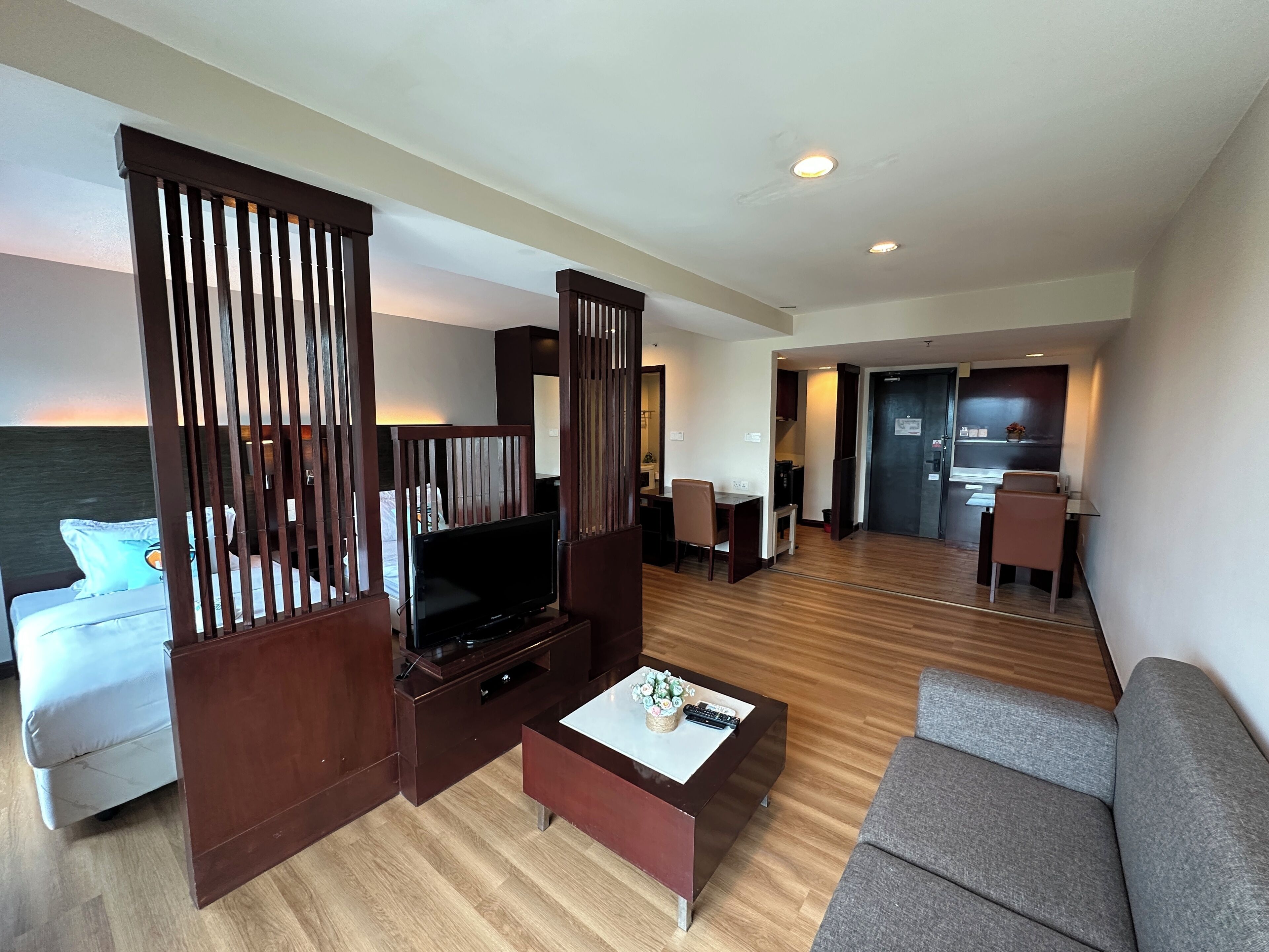 Ein modernes Hotelzimmer mit Fernseher, Sofa, Couchtisch und Meerblick.