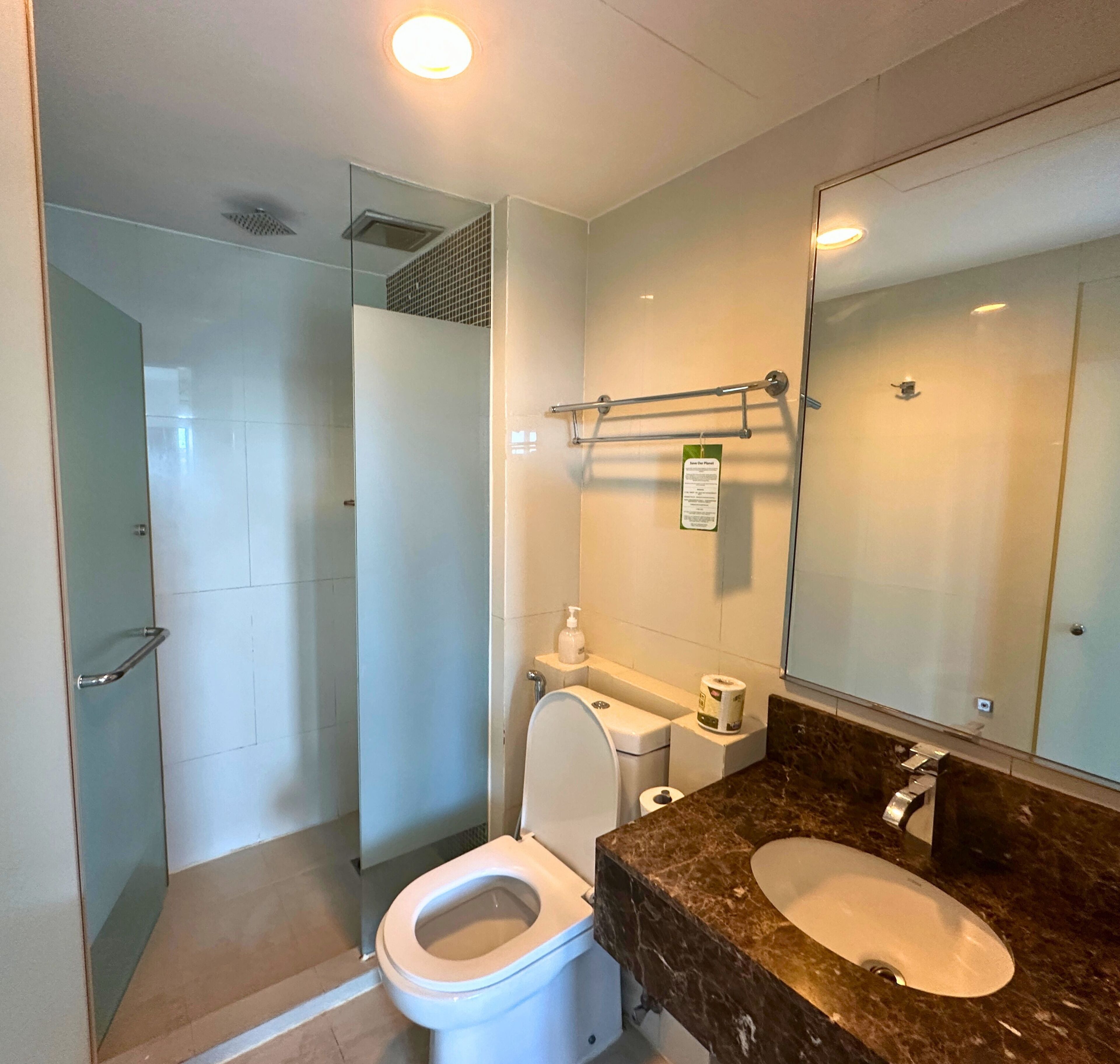 A modern bathroom with a toilet, sink, and shower.