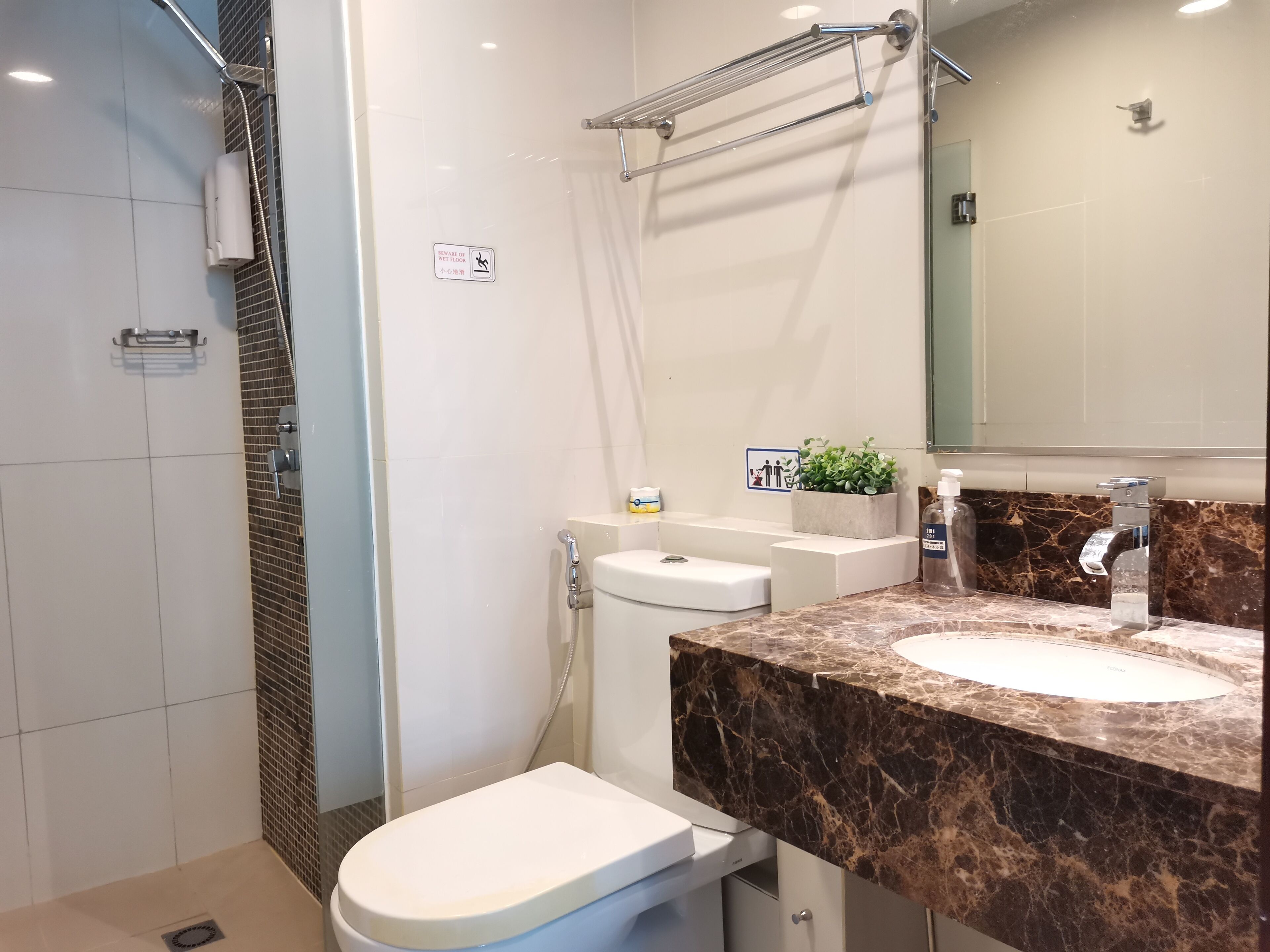 A modern bathroom with a shower, toilet, and sink.