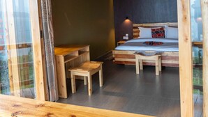 Une pièce avec un cadre en bois, comprenant un lit, une petite table et un banc.