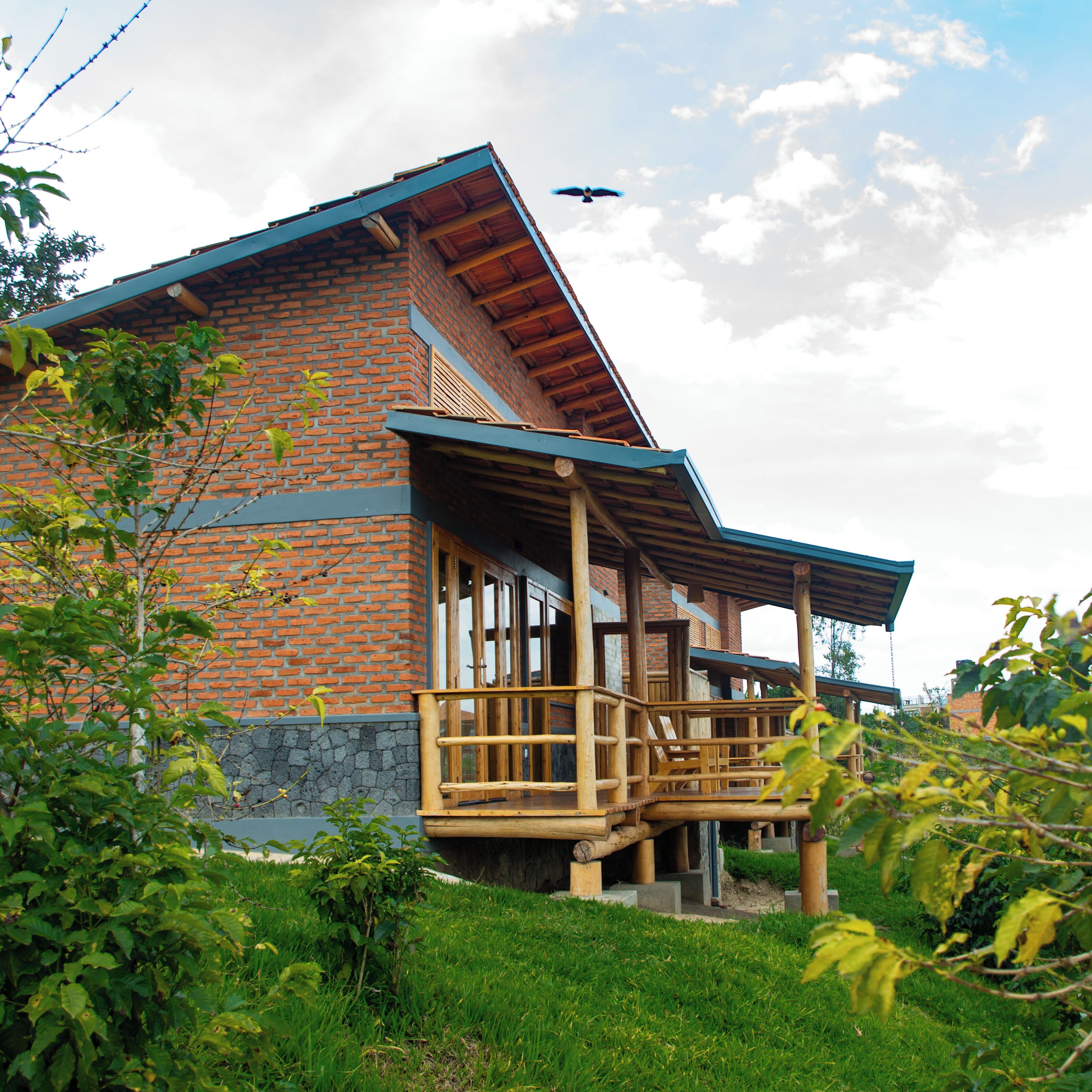 Un bâtiment en briques avec un balcon en bois et un oiseau qui vole dans le ciel.