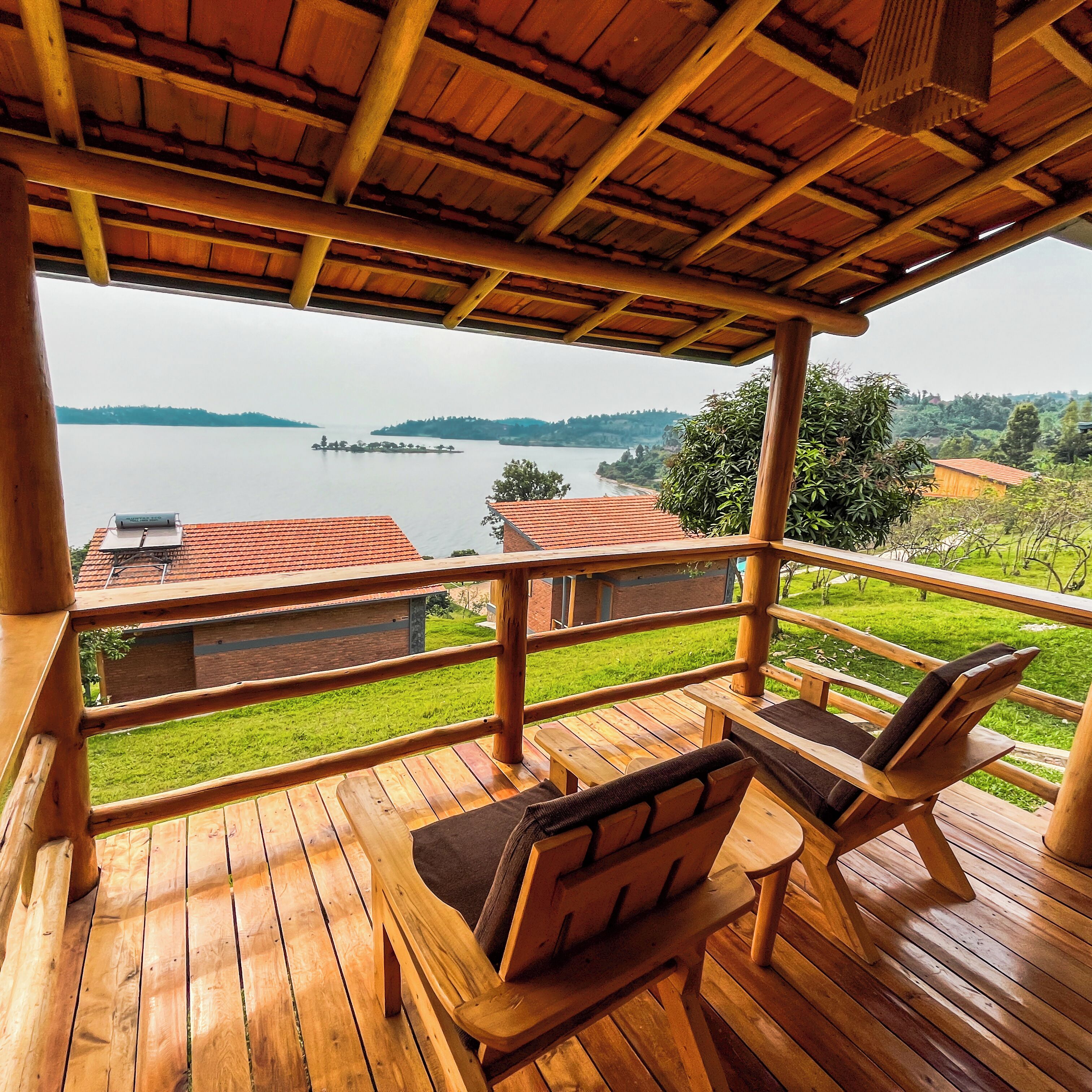 Terraza de madera con vista a un lago y terreno lejano.