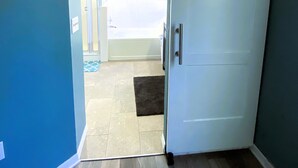 Une pièce dotée d’une porte coulissante donnant accès à une salle de bain avec baignoire et douche.