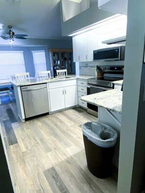 A modern kitchen with white cabinets, a microwave, an oven, and a dishwasher. - Cozy 3/2 in the Middle of all the action
Sleeps 7 3 beds 2 bath & air mattress (Lakeland)