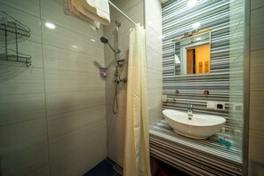 A modern bathroom with a shower, a sink, and a striped mirror backsplash. - Loft 1 apartments New Gudauri (Kazbegi)
