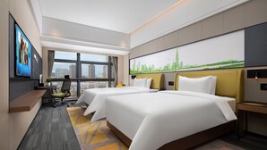 A modern hotel room with two beds, a desk, a TV, and a cityscape view.