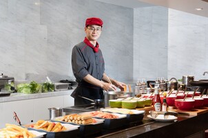 A buffet setup with various food items and condiments.