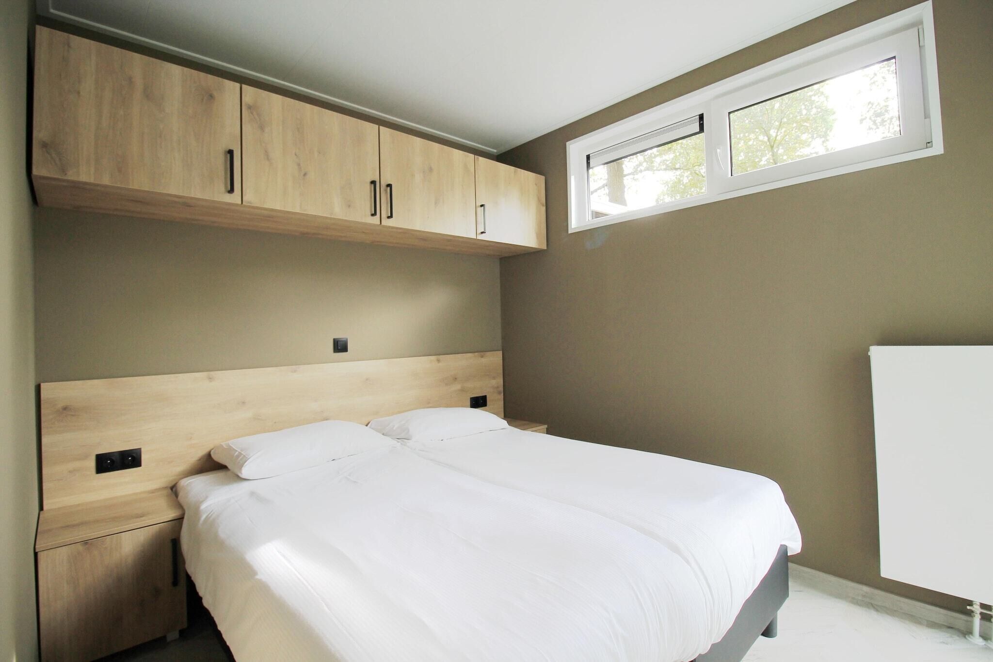 Ein Schlafzimmer mit Bett, Holzschränken, einem Fenster und einer Heizung.