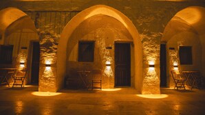 An interior with stone arches, wooden doors, and tables. - Daphne Cave Cappadocia (Avanos)