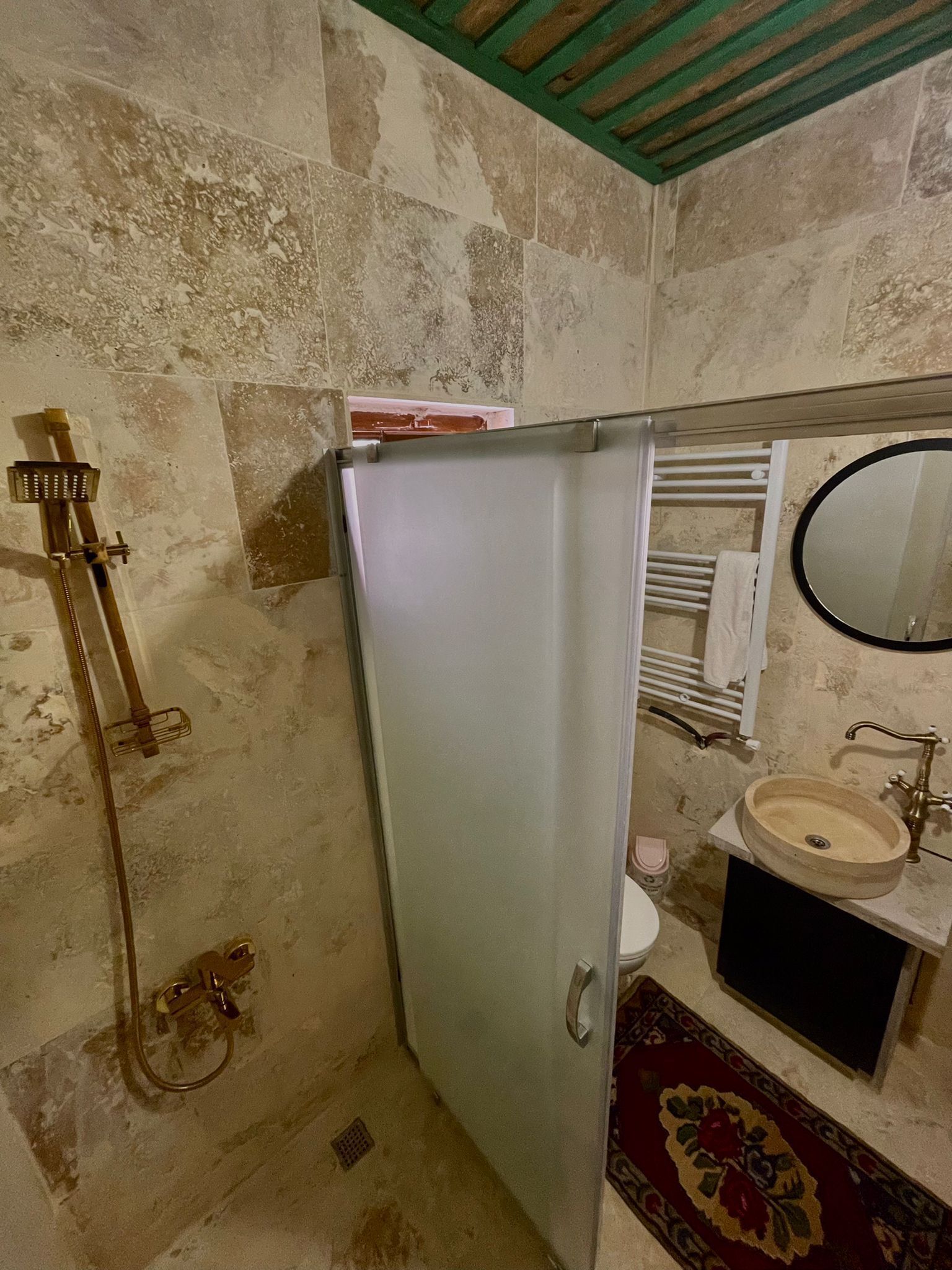 Un bagno con doccia, WC, lavandino e uno specchio.