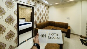 Une chambre d’hôtel avec un lit, un canapé marron et une pancarte indiquant « 101, votre refuge ».