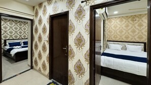 Une chambre d’hôtel avec un grand miroir, deux lits, une armoire et une porte.