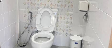A small, clean bathroom with a toilet, a bidet, and a trash bin.