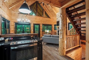 Experience the warmth of a log cabin-style home with a spacious kitchen, cozy living area, and stunning forest views.