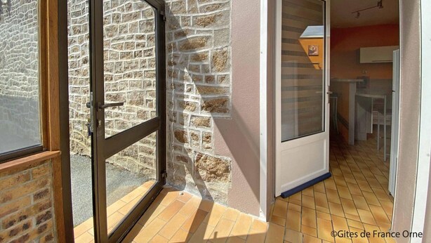 A room with a stone wall, a wooden door, and a tiled floor. - Charming granite house with enclosed garden, all inclusive, near Domfront (Saint-Mars-d'Égrenne)