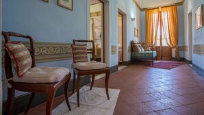 A hallway with two wooden chairs, a bed with a metal frame, and a window with curtains. - Villa Astro - Homelike Villas (Fabbrica)