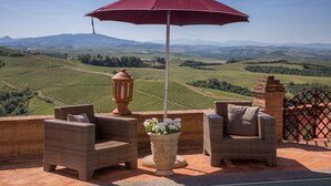 A terrace with wicker furniture, a potted plant, and a red umbrella. - Villa Astro - Homelike Villas (Fabbrica)
