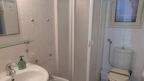 Un baño con lavamanos, bidé, inodoro y cabina de ducha.
