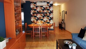 Ein Wohnzimmer mit Essbereich, einer Couch, einem Couchtisch und einem Schrank.