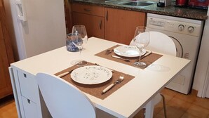 Une table à manger avec deux assiettes, des couverts et des verres à vin, le tout préparé pour deux personnes.