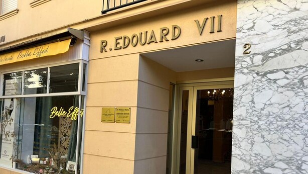 Exterior del R. Edouard VII, con un toldo amarillo que muestra la señalización 'Belle Effet', una entrada de cristal y un suelo de mármol.