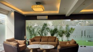 A modern lobby with a sofa set, two coffee tables, and a chandelier. - The Hoften Elite 32 Avenue, Sector 15, Gurugram (Gurugram)