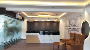 A modern reception area with a marble counter, wooden flooring, and a word cloud wall. - The Hoften Elite 32 Avenue, Sector 15, Gurugram (Gurugram)