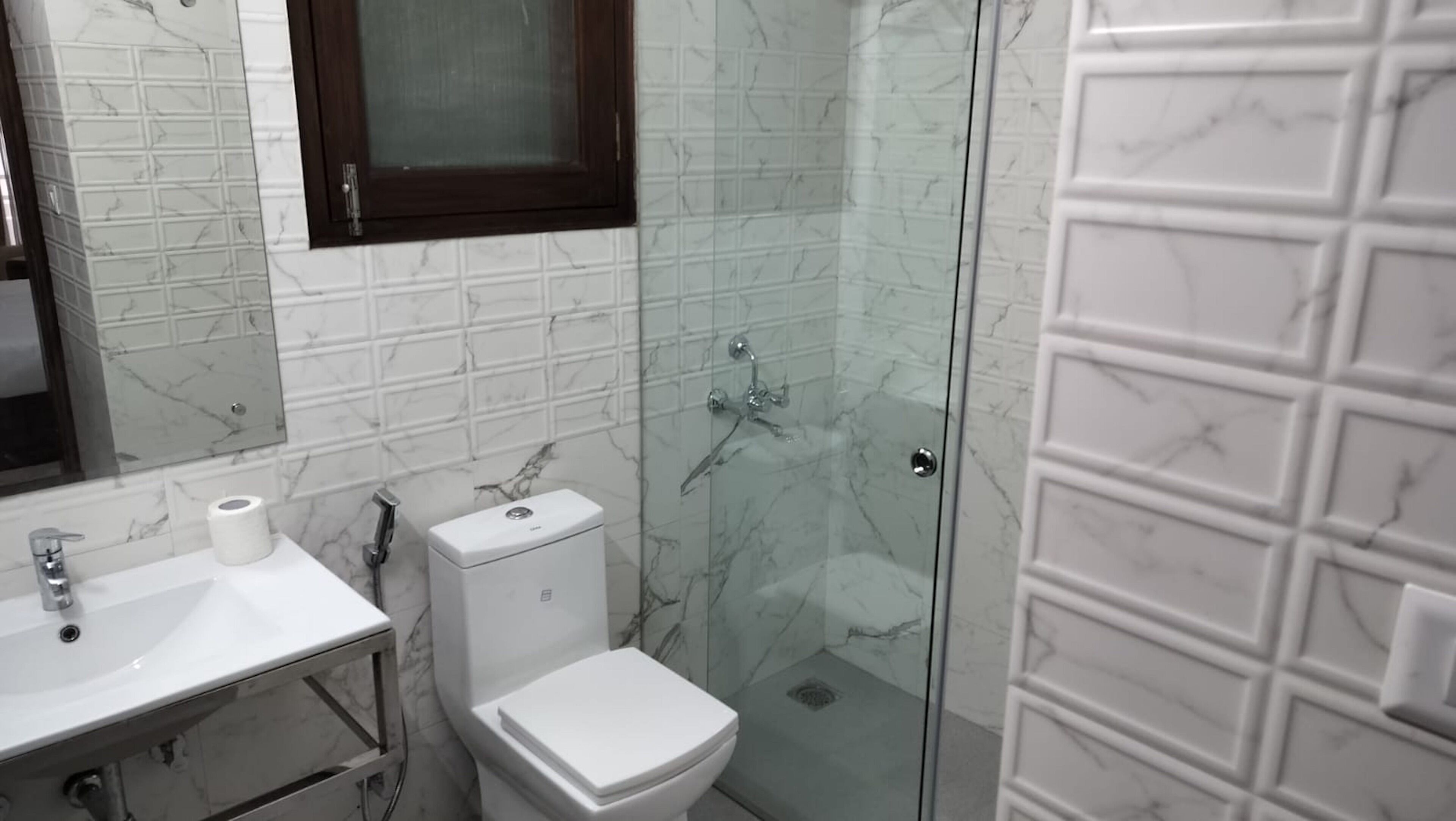 A bathroom with a toilet, sink, and shower area.
