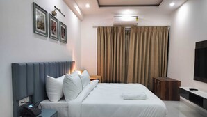 A modern hotel room with a bed, bedside phone, and a TV. - The Hoften Elite 32 Avenue, Sector 15, Gurugram (Gurugram)