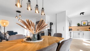 Una cucina moderna con pensili bianchi, un piano di lavoro in legno e un piano cottura nero.