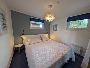 A bedroom with a bed, bedside tables, a window with a view, and a ceiling light fixture. - FLOATING HOUSES - Comfortable floating vacation homes at the Barth marina (Barth)