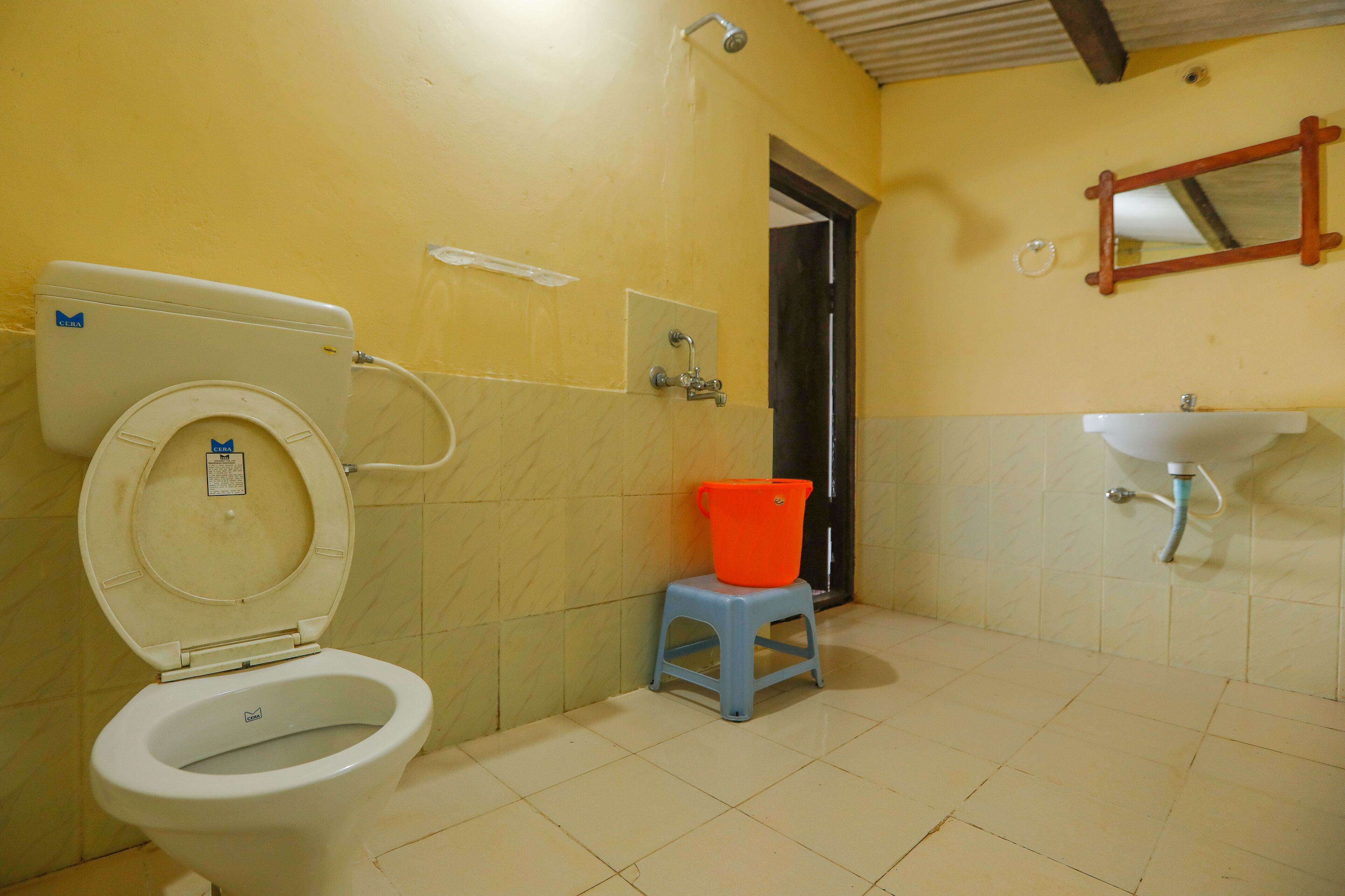 Een badkamer met een toilet, een wastafel en een spiegel.