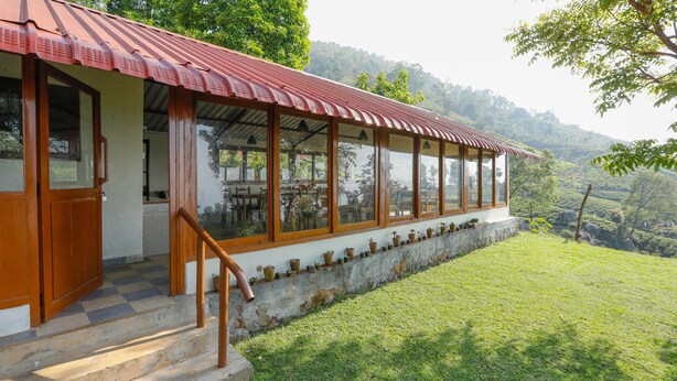 Un edificio con techo rojo, ventanas grandes y cimientos de piedra.