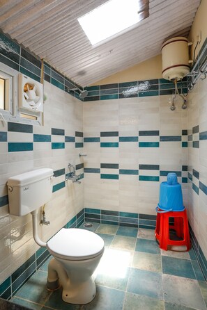 A bathroom with a toilet, a sink, and a shower.