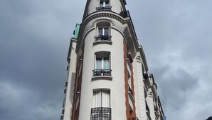 A tall, historic building with a red awning and a sign that reads "TABAC". - Havre de Paix (Montreuil)