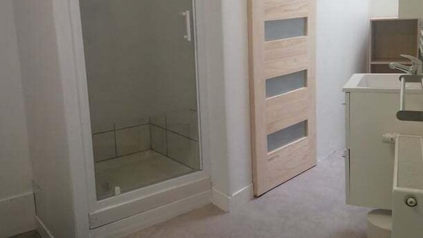 Ein Schlafzimmer mit Bett, begehbarem Kleiderschrank und Bad.