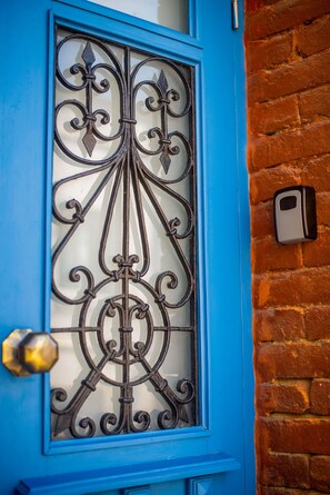 A blue door with a decorative metal grille and a brass doorknob. - H&B apartments Sartichala (Tbilisi)