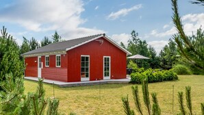 A red building with a flat roof, a front door, and windows.