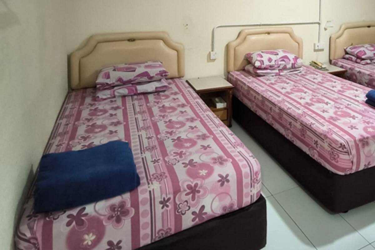 Une chambre d’hôtel avec deux lits, chacun doté d’une tête de lit et d’une table de chevet.