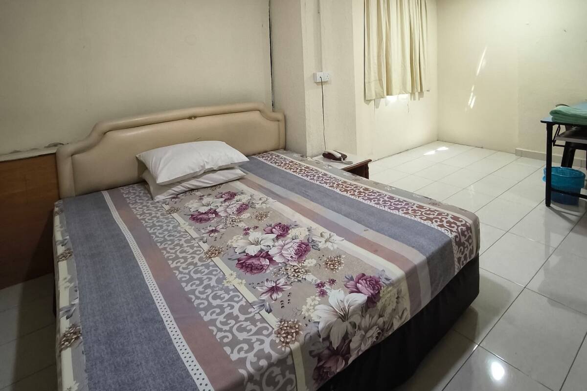 Une chambre à coucher avec un lit, une table de chevet, une table et une chaise.