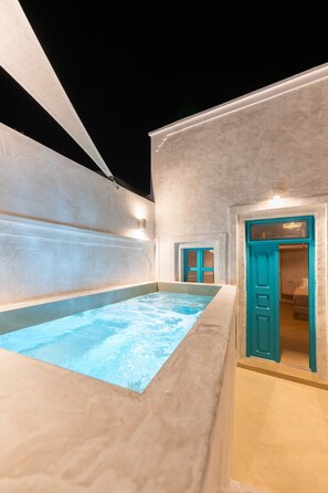 Ein Wellnessbereich mit Whirlpool, einer blauen Tür und einer Wandleuchte.